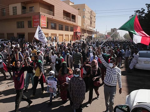 People march during a protest to denounce the October dissolution of the government, in Khartoum, on December 30, 2021.