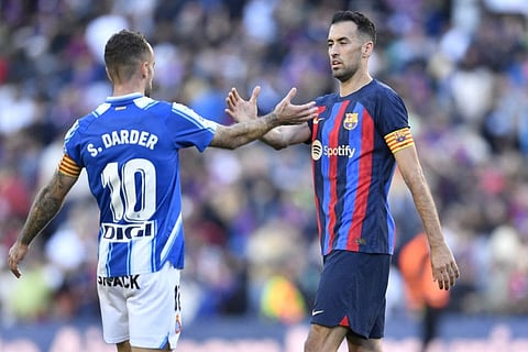 Espanyol's midfielder Sergi Darder (left) shakes hands with Barcelona's midfielder Sergio Busquets at the end of the Spanish League match at the Camp Nou stadium in Barcelona.
