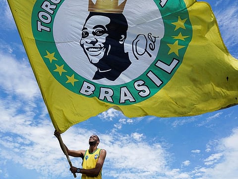 A fan waves a flag with the image of football legend Pele in Tres Coracoes, the city where Pele was born, Minas Gerais state, Brazil on December 30, 2022.