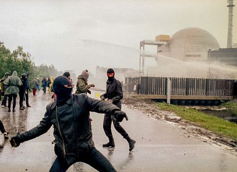 Demonstrators hurl rocks towards police surrounding the nuclear power plant in Brokdorf, West Germany, on June 7, 1986, during riots as anti-nuke demonstrators demand the world-wide switch-off of all nuclear power plants.