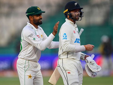 Pakistan's captain Babar Azam (left) gestures with New Zealand's Devon Conway at the end of the fifth and final day of the first Test at the National Stadium in Karachi. The second Test starts tomorrow.
