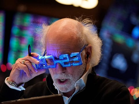 Stock trader Peter Tuchman looks at a clipboard on the floor of the New York Stock Exchange at the closing bell on December 30, 2022 in New York.