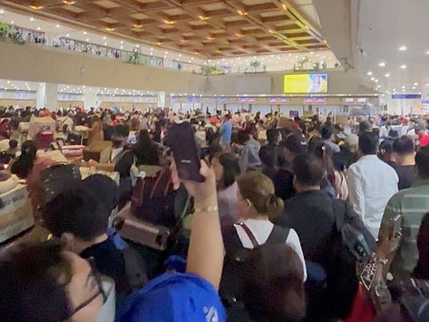 People wait after flights were delayed and cancelled at Ninoy Aquino International Airport, in Manila, Philippines, during a previous techinical glitch on January 1, 2023. File photo.