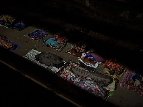 Homeless people sleep in the open under an overpass on a winter night in New Delhi.