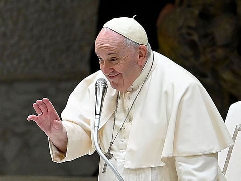 Pope Francis waves to pilgrims as he arrives for the weekly general audience in Paul VI hall at the Vatican on December 28, 2022.