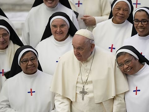 Pope Francis poses for a photo with a group of nuns at the end of his weekly general audience in the Pope Paul VI hall at the Vatican, Wednesday, Jan. 4, 2023.