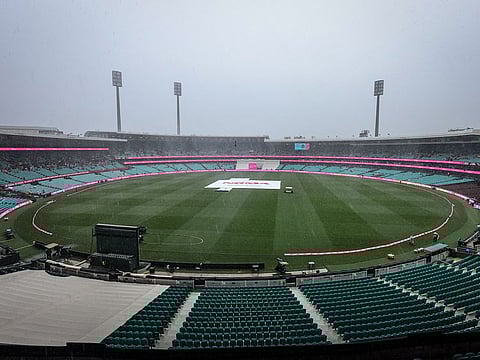Rain falls on the ground with covers over the pitch on day three of the third Test match between Australia and South Africa at the Sydney Cricket Ground (SCG) in Sydney on January 6, 2023.