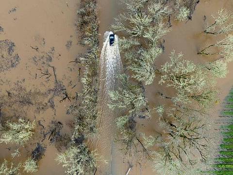 A vehicle drives on a flooded road in Sebastopol, California, on January 05, 2023.