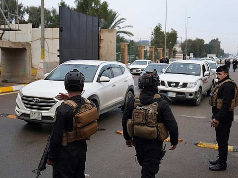 Iraqi security forces stand guard as they check motorists entering the Green Zone, in Baghdad, Iraq, Sunday, Jan. 8, 2023.
