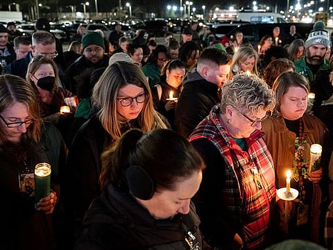 Attendees hold their heads down for a prayer during a vigil for Abby Zwerner, the teacher shot by a 6-year-old student at Richneck Elementary.
