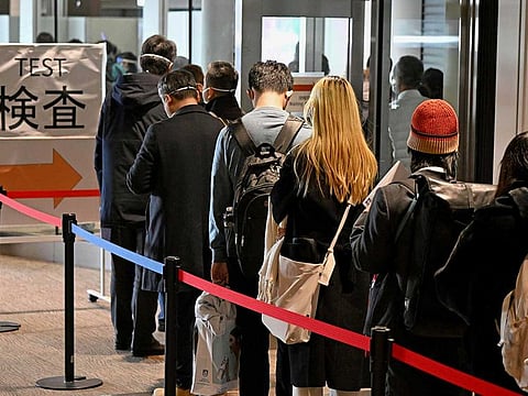 Passengers from Shanghai line up to take a higher-sensitivity COVID-19 antigen test o their arrival at Narita airport near Tokyo on Jan. 8, 2023.