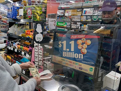A Mega Millions customer purchases her tickets for the estimated jackpot at the Fuel On Convenience Store in Pittsburgh