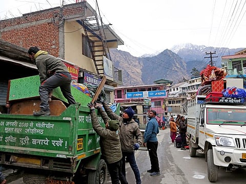 Locals move their belongings after the district administration declared their houses unsafe following cracks widening due to land subsidence, at Joshimath, in Chamoli on Wednesday, Jan 11, 2023.