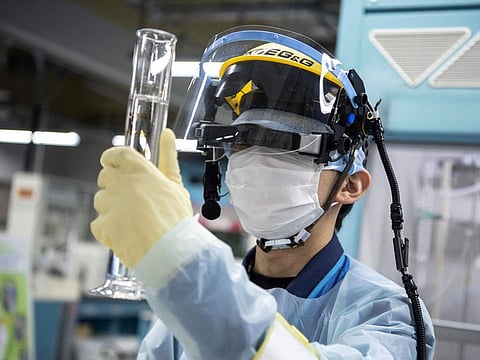 This file picture taken on March 5, 2022 shows an employee conducting a tritium measurement on a sample of contaminated water at the Tokyo Electric Power Company (TEPCO) Fukushima Dai-ichi nuclear power plant in Okuma, Fukushima prefecture