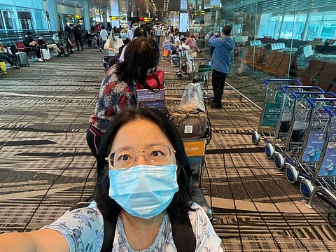 Chu Wenhong poses for a selfie before boarding her flight to China ahead of the Chinese Lunar New Year, her first time going home since COVID-19 pandemic, in Singapore on January 12, 2023.