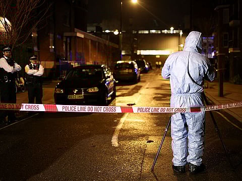 Forensics officers work at the scene of a shooting, the attack reportedly happened during a funeral at St Aloysius Church, in London.