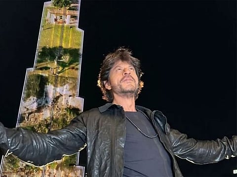 Shah Rukh Khan or SRK, one of India’s biggest movie stars, famous for his stellar roles, doing his signature pose in front of Dubai’s Burj Khalifa