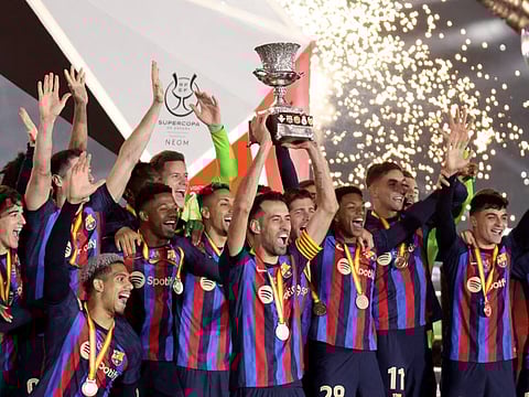 Barcelona's Sergio Busquets lifts the trophy as he celebrates with teammates after winning the Spanish Super Cup at King Fahd Stadium, Riyadh, Saudi Arabia.