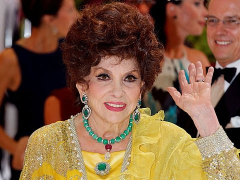Italian actress Gina Lollobrigida waves as she arrives at the Red Cross Gala in Monte Carlo August 1, 2014.