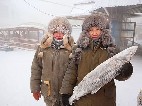 Fish vendors Marina Krivolutskaya and Marianna Ugai pose for a picture at an open-air market on a frosty day in Yakutsk, Russia.