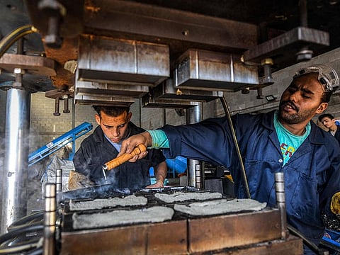 A worker prepares moulds of plastic waste at a workshop of the startup company 'TileGreen'.