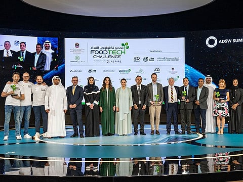 Winners (holding trophies) with UAE officials at the award ceremony in Abu Dhabi. Two winners are from the UK, and one each from the UAE and the Netherlands