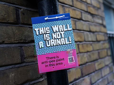 A board indicating that the walls of the area are covered by anti-pee paint in Soho.