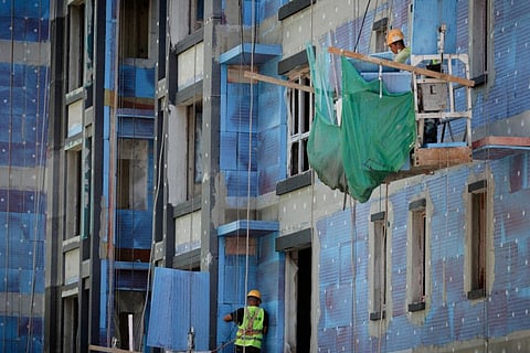 Men work at a construction site of apartment buildings in Beijing, China.
