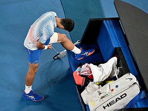 Serbia's Novak Djokovic adjusts his bandage as he competes against France's Enzo Couacaud during their men's singles match on day four.