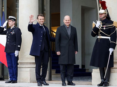 France's President Emmanuel Macron waves next to German Chancellor Olaf Scholz as they arrive to attend a cabinet meeting as part of the celebration of the 60th anniversary of the signing of the Elysee Treaty in Paris, France January 22, 2023.