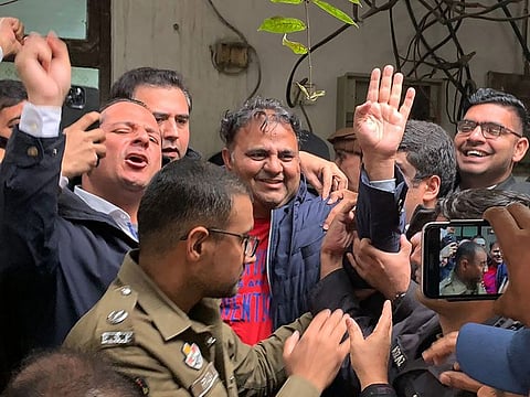 Police officials escort the arrested leader of opposition Pakistan Tehreek-e-Insaf (PTI) party, Fawad Chaudhry (centre), to present him before a court in Lahore on January 25, 2023.