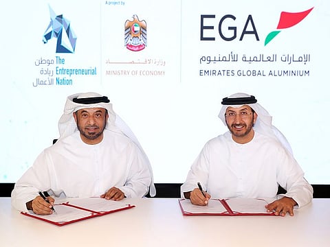 Abdulla Al Saleh (right) of the Ministry of Economy and Khalid Essa Buhumaid sign the agreement.