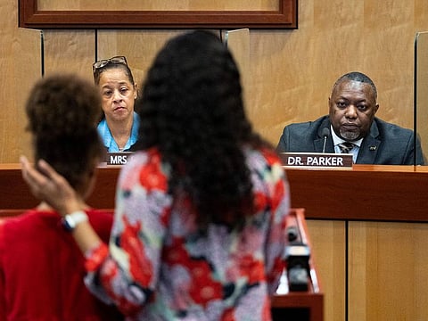 Djifa Lee, a second-grade teacher at Saunders Elementary, center, stands with her daughter as she speaks in front of the Newport News School Board at the Newport News Public Schools Administration building on Jan. 17, 2023, in Newport News, Va., following a shooting at Richneck Elementary by a six-year-old that left a teacher in critical condition.