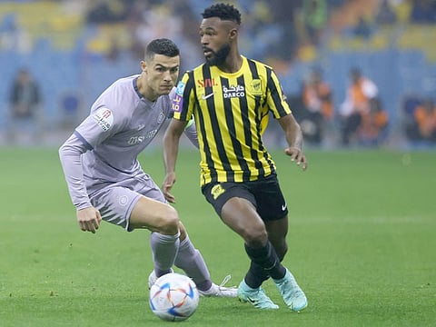 Ittihad's Saudi defender Muhannad Al Shanqeeti (R) is marked by Nassr's Portuguese forward Cristiano Ronaldo during the Saudi Super Cup semi-final at the King Fahd Stadium in Riyadh on January 26, 2023.