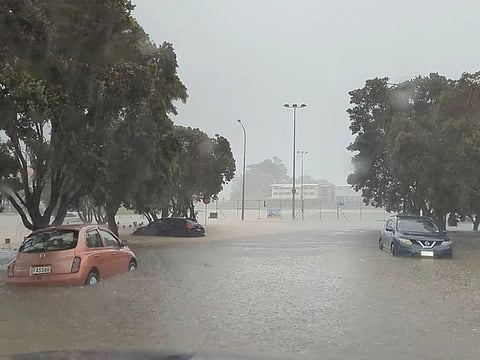 Cars are seen in a flooded street during heavy rainfall in Auckland, New Zealand.
