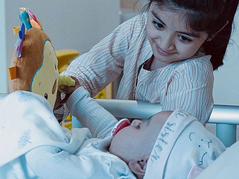 Eight-year-old Nazia, who donated bon marrow, plays with her 9-month old-sister in Abu Dhabi
