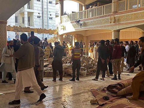 Security officials inspect the site of a mosque blast inside the police headquarters in Peshawar on January 30, 2023.