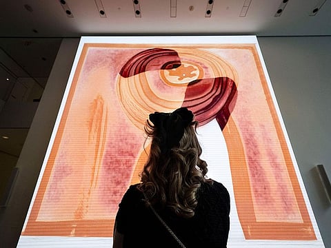 A visitor looks at artist  Refik Anadol's "Unsupervised" exhibit at the Museum of Modern Art in New York. The new AI-generated installation is meant to be a thought-provoking interpretation of the New York City museum's prestigious collection.