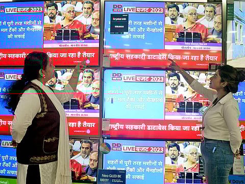 People watch a live telecast of Union Budget 2023-24 presentation at an electronic showroom, in Kolkata.
