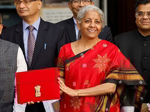 India's Finance Minister Nirmala Sitharaman holds up a folder with the Government of India's logo as she leaves her office to present the federal budget in the parliament, in New Delhi
