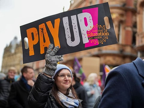 A striking teacher holds a banner which reads "Pay Up" during joint strike action by train drivers, teachers, university staff and civil servants, in Leeds, UK, on Wednesday, Feb. 1, 2023.