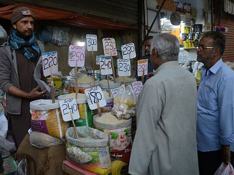 People buy rice at a wholesale market in Karachi on February 1, 2023. - Inflation has risen to a 48-year high in crisis-hit Pakistan, where the International Monetary Fund is visiting for urgent talks, according to data released on February 1 by the country's statistics bureau. (Photo by Rizwan TABASSUM / AFP)