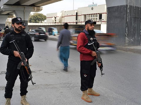 Policemen stand guard along a street in Peshawar on February 1, 2023.