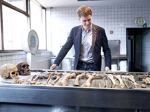 Researcher Bernard Wilkin poses next to skeletons from soldiers who fought in the Battle of Waterloo in 1815, at the Institute for Forensic Medicine of Liege.