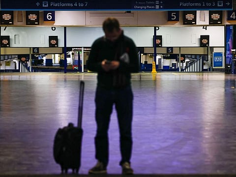 A commuter stands outside London Euston railway station during strike action by train drivers in London on Feb. 3, 2023.