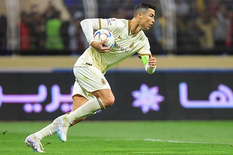 Al Nassr's Portuguese forward Cristiano Ronaldo runs with the ball after scoring a penalty during the Saudi Pro League match against Al Fateh at the Prince Abdullah bin Jalawi Stadium in al-Hasa.