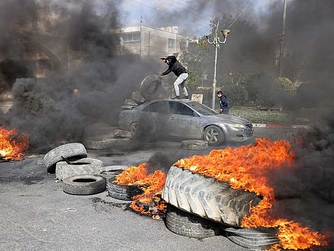 In this file photo, Palestinian protesters burn tyres to block a road leading into Jericho in the occupied West Bank, on February 6, 2023, following a raid in town by Israeli forces.