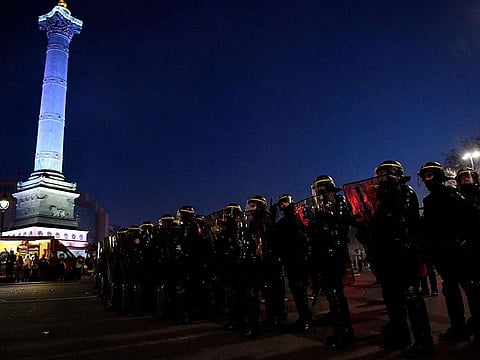 CRS riot police stand in formation on the Place de la Bastille at the end of a demonstration on the third day of nationwide rallies and strikes against a pensions reform plan in Paris.