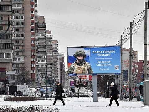 A billboard with an image of a Russian service member and the slogan reading "Glory to the Heroes of Russia!" decorates a street in Saint Petersburg on February 6, 2023.