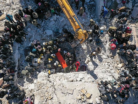 An aerial picture shows rescuers searching the rubble of buildings for casualties and survivors in the village of Salqin in Syria.